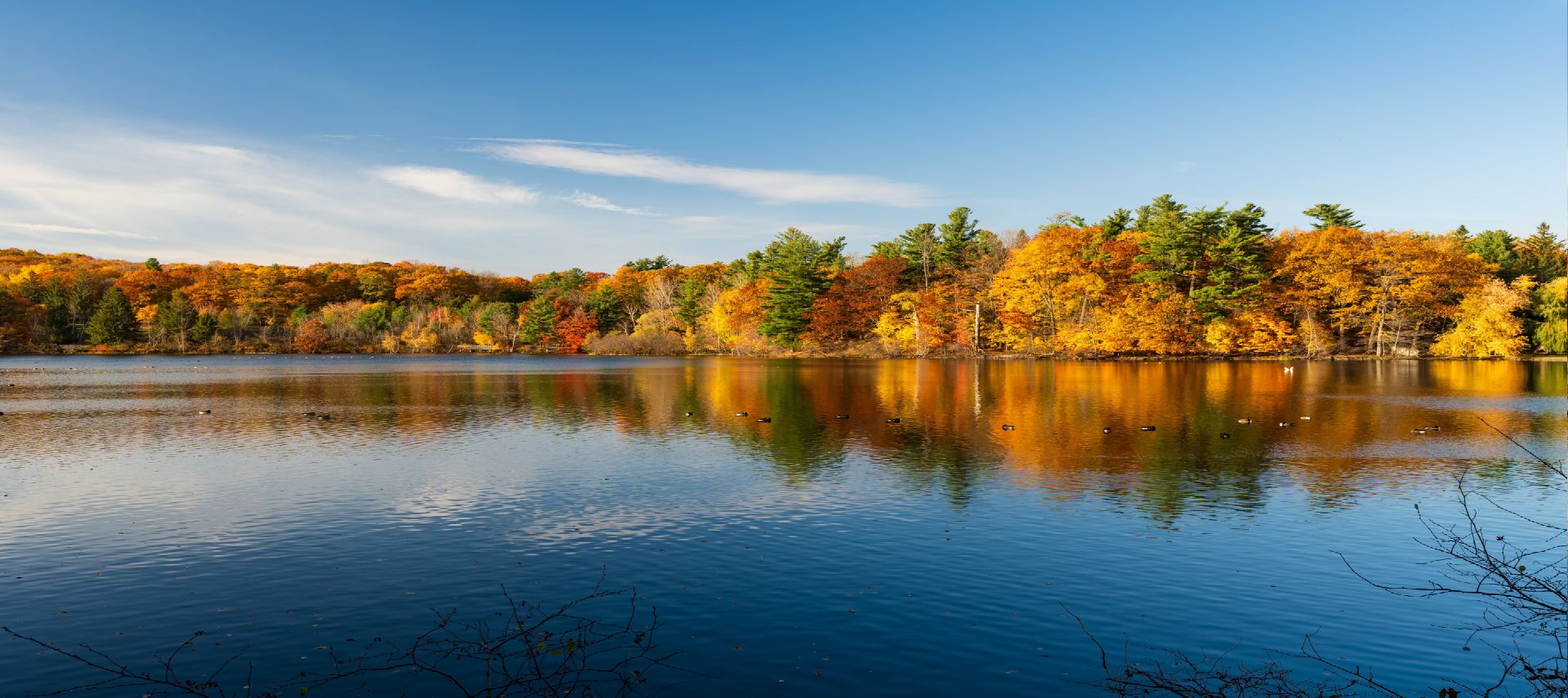 A calm lake surrounded by colorful autumn trees reflecting in the water.