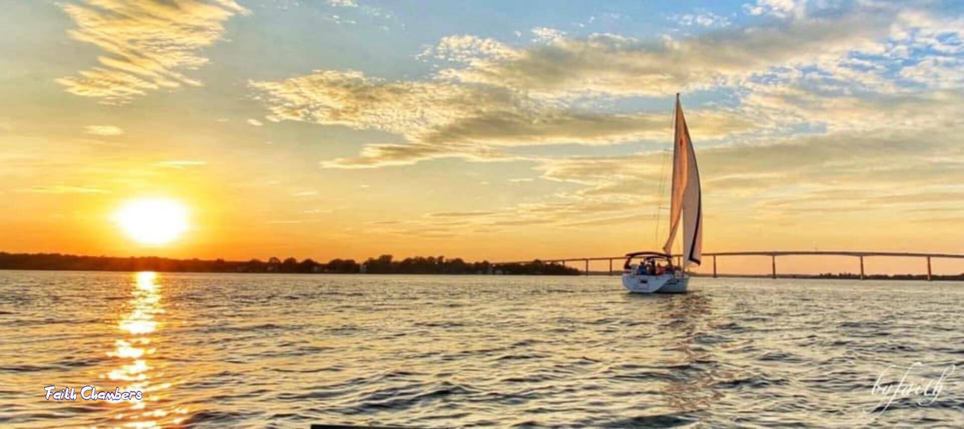 Sailboat on river sunset and bridge
