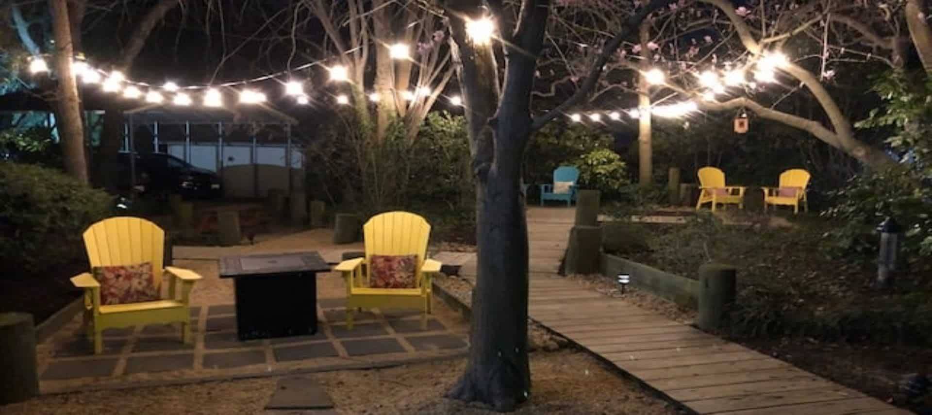 yellow chairs on garden with lights overhead